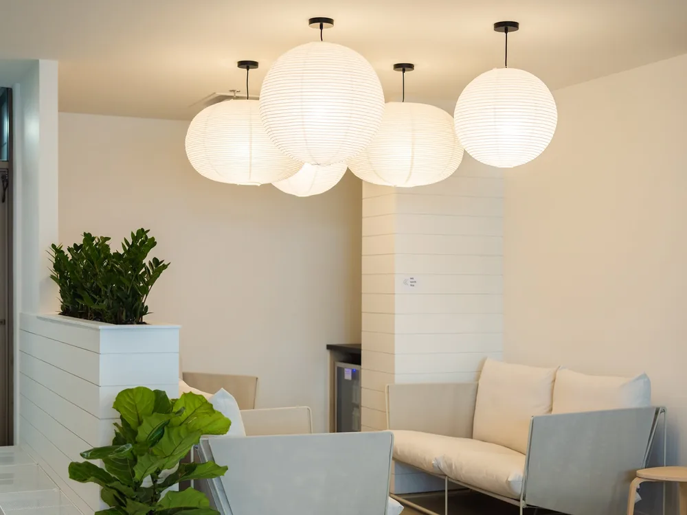 Paper globe lanterns glowing over the couches and plants in the 124 Street lounge.