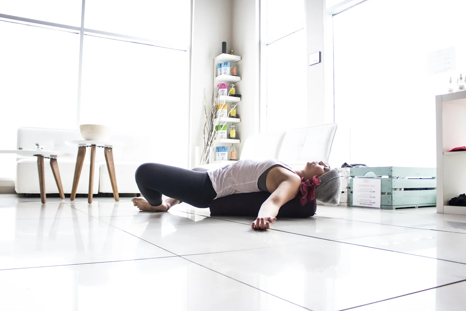 A Yogalife student resting in a supported reclined yoga pose.