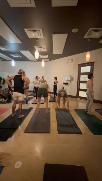 Students standing at the tops of their mats in the studio, waiting to begin the next round.