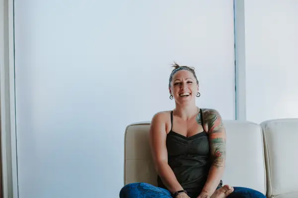 A member sitting cross-legged on the studio couch, laughing.