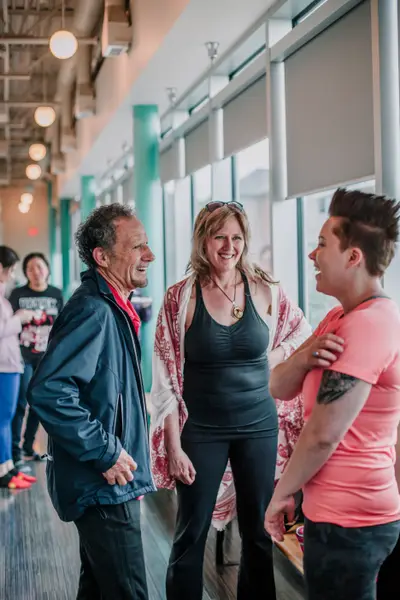 Three people laughing together in the studio lobby.